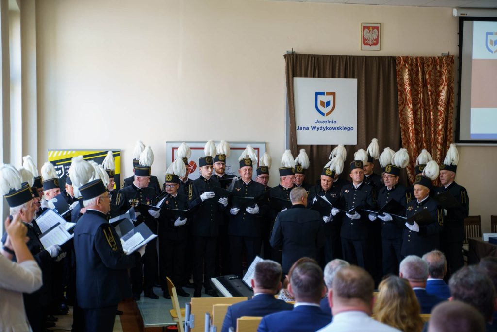 Chór w mundurach górniczych i czakach z białymi pióropuszami występuje podczas inauguracji roku akademickiego.