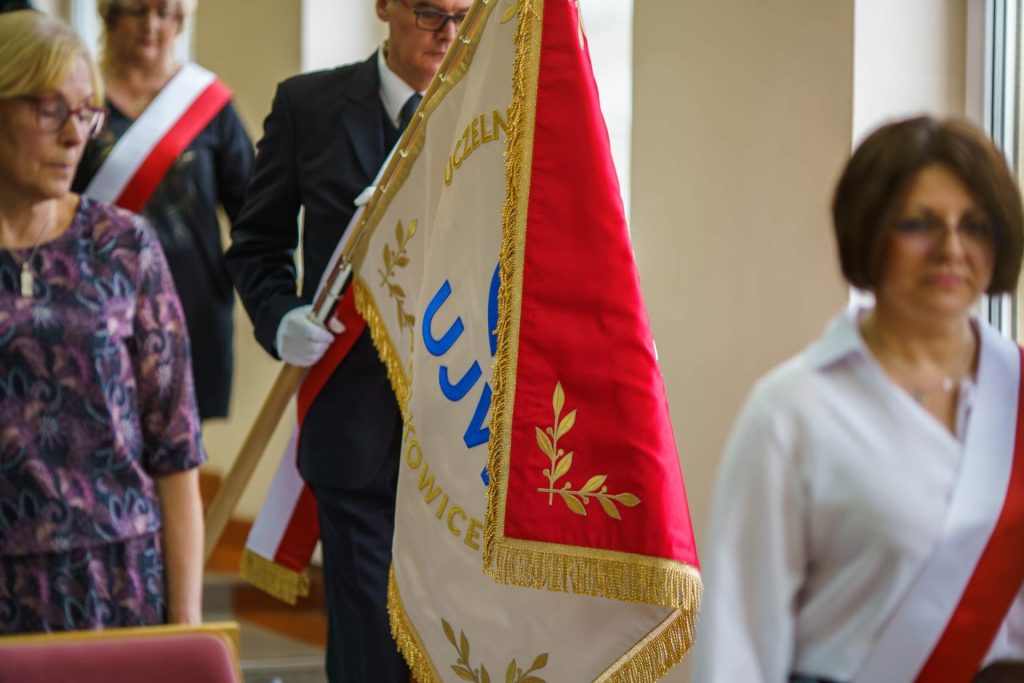 Poczet sztandarowy z biało-czerwonymi szarfami wnosi sztandar UJW do auli.