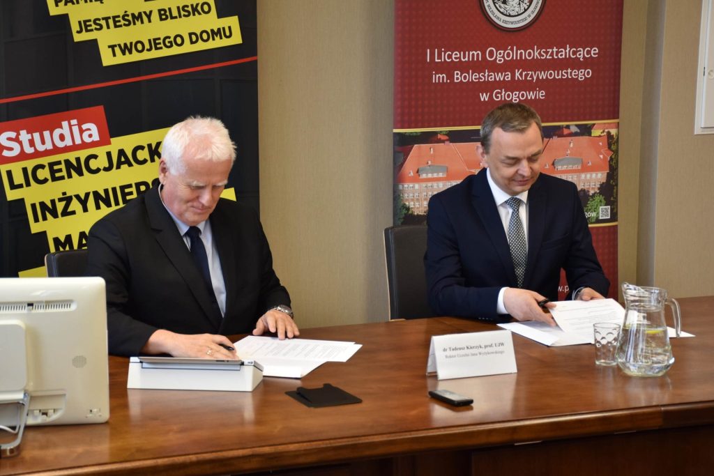 Przedstawiciele UJW i I LO w Głogowie przeglądają dokumenty przy stole.