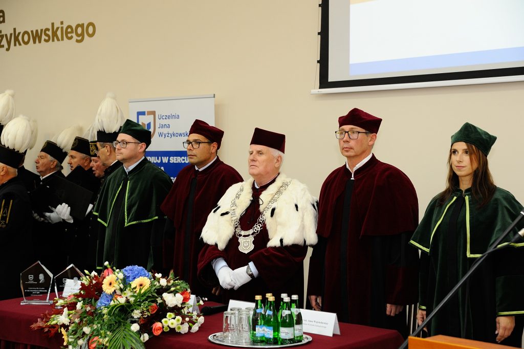Władze uczelni stoją za stołem prezydialnym