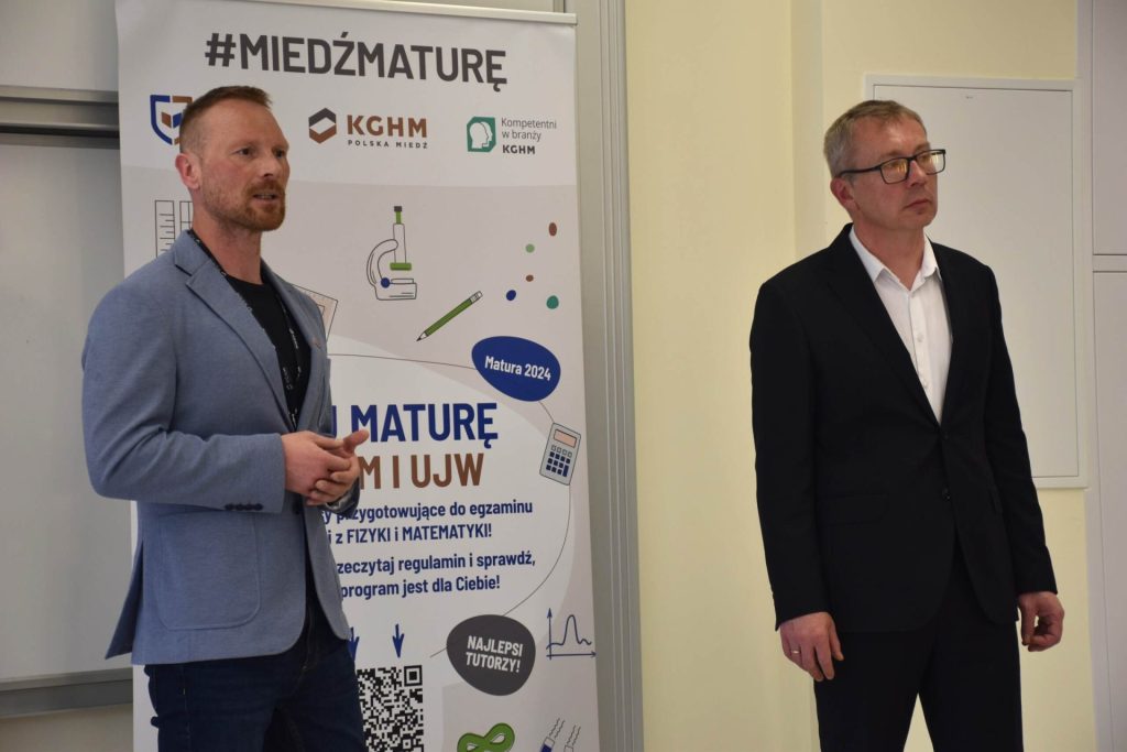 2 mężczyzn stoi, jeden z nich przemawia