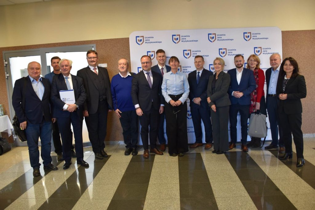 Uczestnicy konferencji o społecznościach lokalnych pozują wspólnie przy ściance UJW.