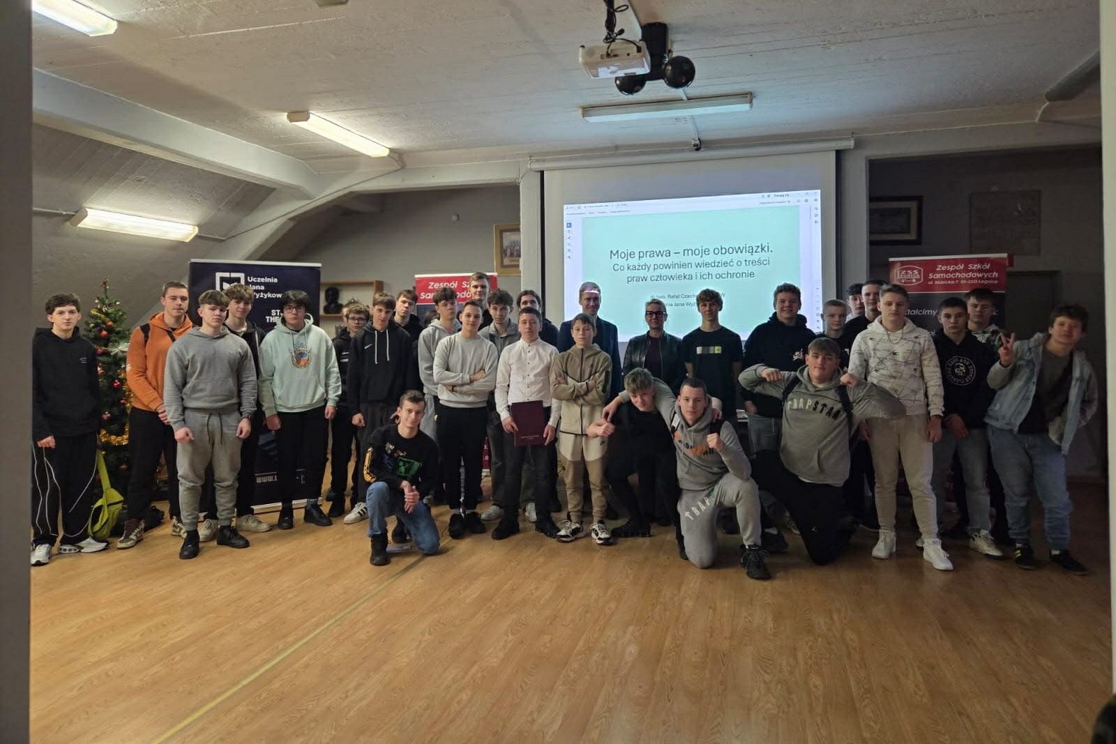 na zdjęciu grupa uczniów, dziekan ujw oraz kierowniczka biura promocji ujw stoją do zdjęcia