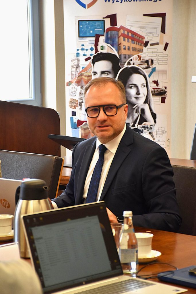 Uczestnik II Posiedzenia Rady Dyrektorów UJW siedzi przy stole z laptopem.
