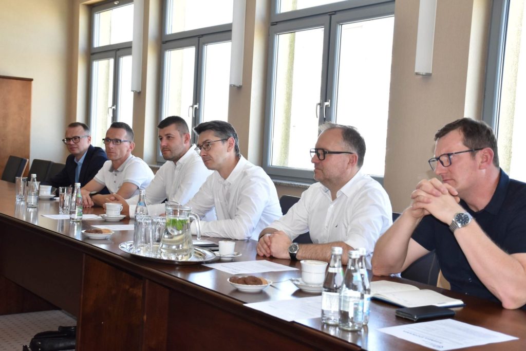 Uczestnicy spotkania UJW z KGHM INOVA siedzą przy stole konferencyjnym.