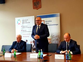 Mężczyzna w okularach zabiera głos podczas spotkania z przedstawicielami UJW.
