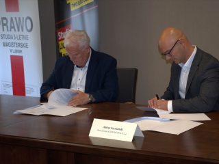 Podpisywanie umowy współpracy UJW z KGHM Metraco przy stole konferencyjnym.