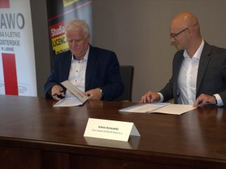 Przedstawiciele UJW i KGHM Metraco porządkują teczki z dokumentami przy stole.