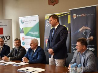 Przedstawiciel partnera przemawia podczas spotkania UJW z CBJ, Mercus Logistyka i PeBeKa.