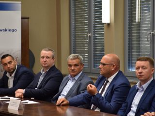 Uczestnicy klastra energetycznego słuchają wypowiedzi mężczyzny w niebieskim garniturze.