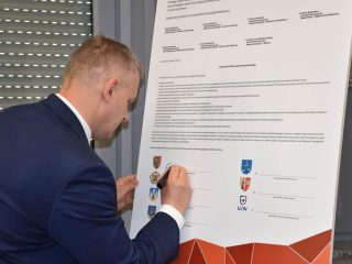 Podpisywanie dokumentu klastra energetycznego umieszczonego na sztaludze.