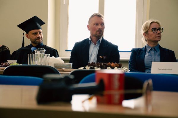 2 mężczyzn i 1 kobieta siedzą za stołem