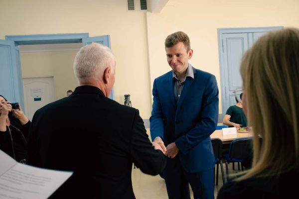 Mężczyzna ściska dłoń drugiemu mężczyźnie