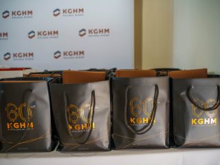 Czarne torby upominkowe z jubileuszowym logo 60-lecia KGHM ustawione w rzędzie.