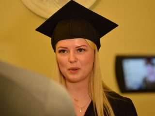 Absolwentka w birecie udziela wywiadu przed kamerą.