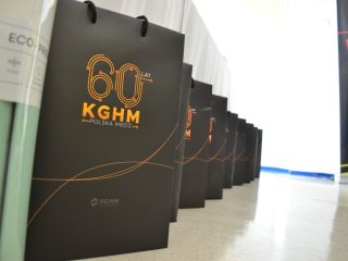 Czarne torby z jubileuszowym logo 60-lecia KGHM ustawione w rzędzie.