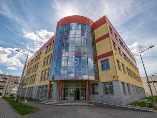 Wejście do UJW pod wysokim, zaokrąglonym przeszkleniem fasady.