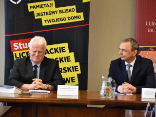 Przedstawiciele UJW i I LO w Głogowie rozmawiają przy stole z dokumentami.