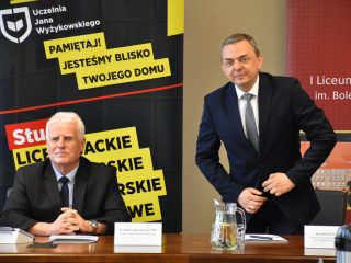 Przedstawiciel liceum zabiera głos przy stole obok przedstawiciela UJW.