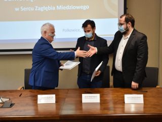 Sygnatariusze porozumienia Scanway podają sobie dłonie nad stołem z dokumentami.