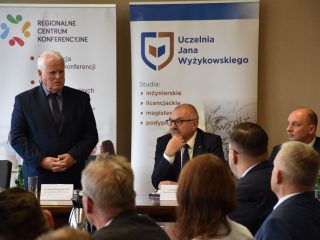 Siwowłosy przedstawiciel UJW przemawia przed uczestnikami spotkania z marszałkiem.