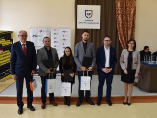 Sześcioro uczestników uroczystości pozuje z teczkami i torbami upominkowymi.