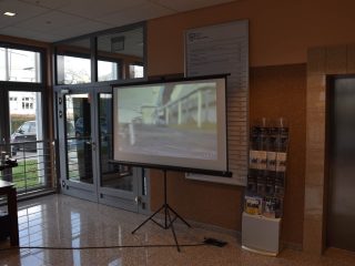 Ekran prezentacyjny ustawiony w holu UJW podczas konferencji.
