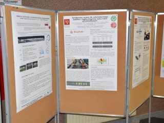 Plansze z posterami naukowymi zawierającymi schematy, wykresy i logotypy.