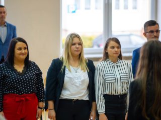 Trzy studentki stoją w szeregu podczas uroczystości ślubowania.