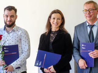 Kobieta i dwaj mężczyźni prezentują fioletowe teczki z dokumentami.