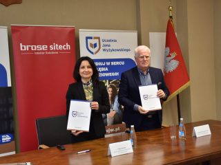 kobieta i mężczyzna prezentują teczkę z podpisaną umową