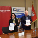 kobieta i mężczyzna prezentują teczkę z podpisaną umową