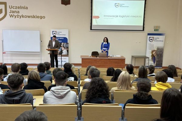 Sala wykładowa. Młodzi ludzi siedzą i słuchają wykładu