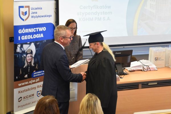 Wręczenie dokumentu absolwentce w todze i birecie podczas uroczystości w UJW.