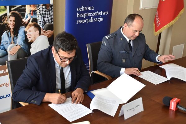 Podpisywanie porozumienia przez przedstawiciela UJW i funkcjonariusza Służby Więziennej.