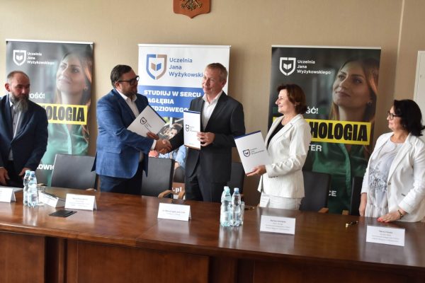Uścisk dłoni i prezentacja dokumentów podczas spotkania partnerskiego UJW.