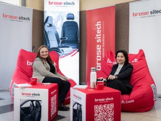 Dwie kobiety siedzą na czerwonych pufach w strefie wypoczynku Brose Sitech.
