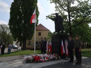 Warta przy pomniku udekorowanym polskimi flagami i wieńcami podczas obchodów 3 Maja.