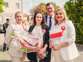 Delegacja z biało-czerwonym wieńcem i polską flagą podczas obchodów Święta Konstytucji 3 Maja.