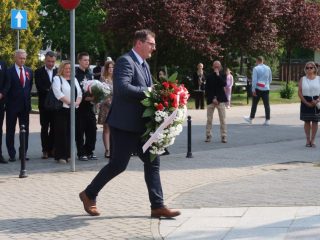 Mężczyzna niesie biało-czerwony wieniec podczas uroczystości Święta Konstytucji 3 Maja.