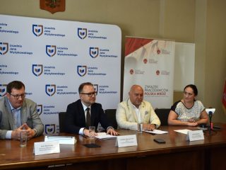 Przedstawiciele UJW i Związku Pracodawców Polska Miedź siedzą przy stole podczas spotkania.