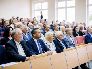 Goście inauguracji roku akademickiego siedzą w wypełnionej auli.