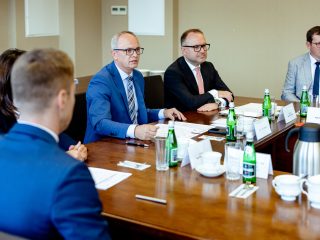 Mężczyzna w niebieskim garniturze zabiera głos podczas posiedzenia Konwentu.
