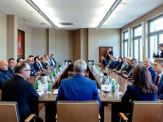 Uczestnicy pierwszego posiedzenia Konwentu UJW siedzą przy długim stole konferencyjnym.