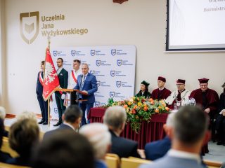 Mężczyzna w niebieskim garniturze przemawia przy mównicy podczas inauguracji UJW.