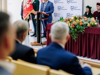 Wystąpienie gościa inauguracji przy poczcie sztandarowym, widziane z publiczności.