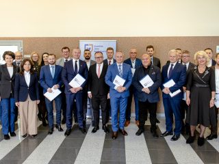 Wspólne zdjęcie członków Konwentu UJW z dokumentami w holu uczelni.