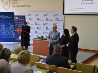 Prowadząca przy mównicy i przedstawiciele organizatorów podczas otwarcia konferencji.
