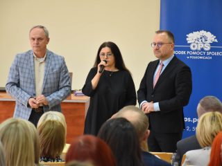 Kobieta w czarnej sukience przemawia do mikrofonu podczas otwarcia konferencji.