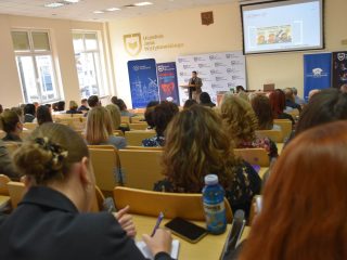 Widok z widowni na prelegentkę i ekran prezentacji podczas konferencji OPS.